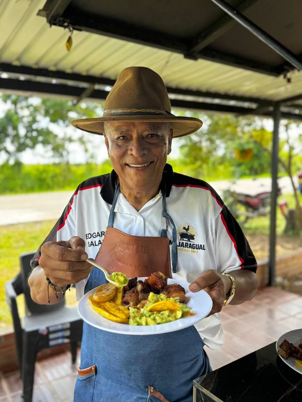 Don Edgar, dueño de Mi Jaragual, sirviendo un plato de asado